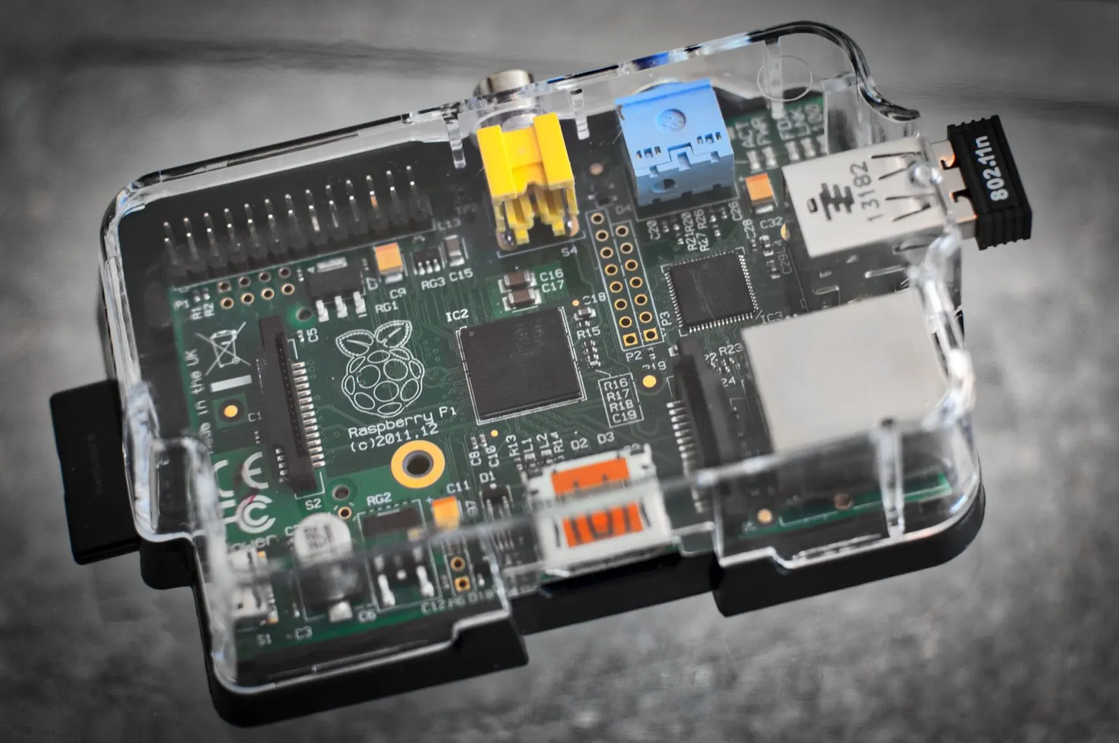 Detailed image of a Raspberry Pi microcomputer circuit board in a clear case.